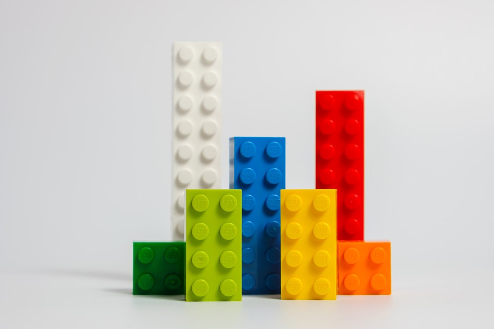 Multicolored Lego blocks, different leghts, standing like buildings, close up